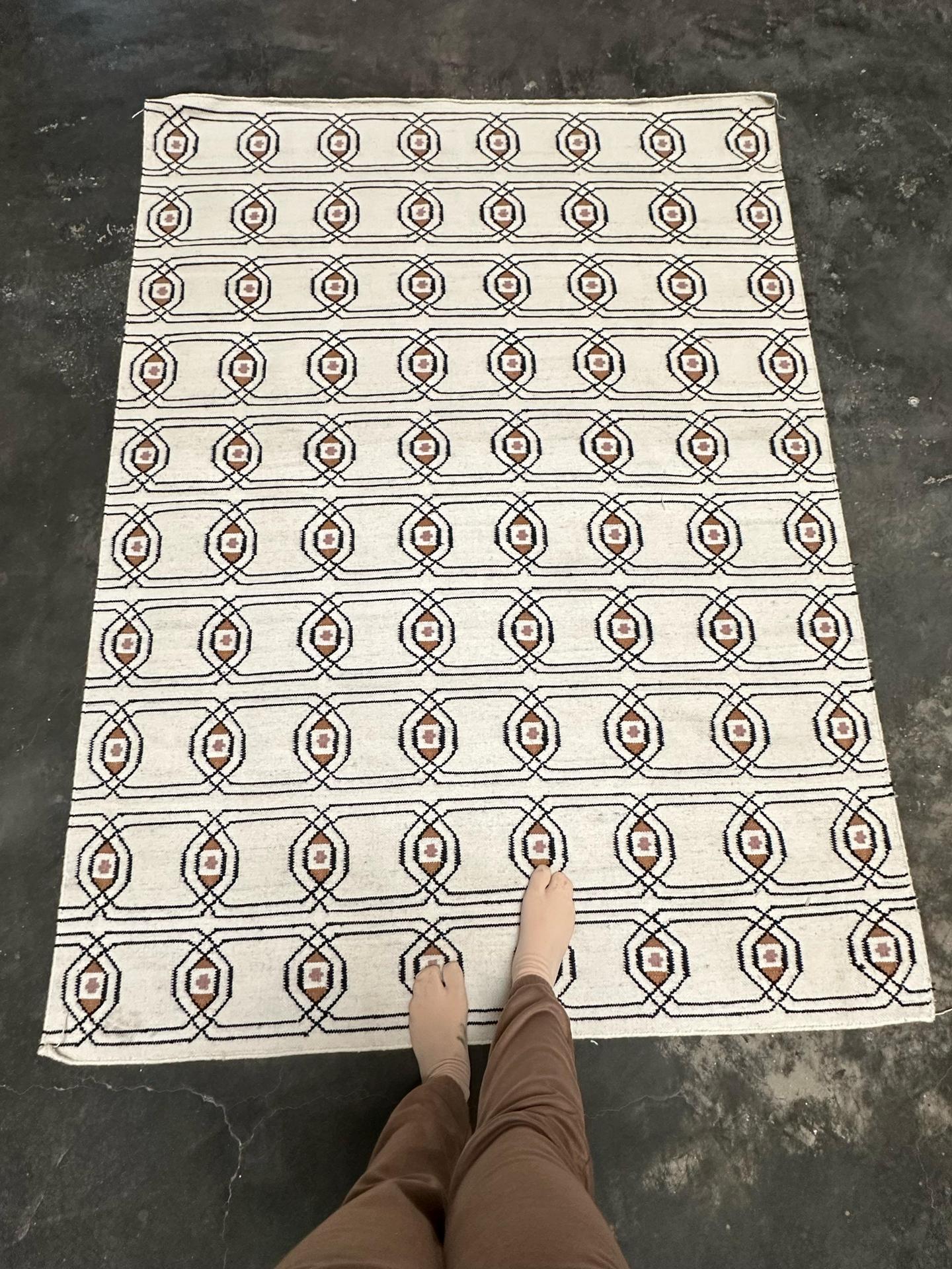 flatweave rug with repeating geometric pattern in ivory and maroon